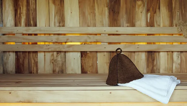 Badstuebenk med håndkle og hatt